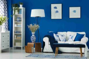 soggiorno con pareti blu e divano bianco con complementi di arredo bianchi