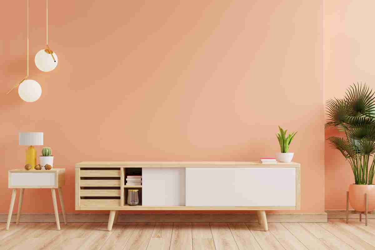 soggiorno con pareti di colore chiaro e mobili moderni in legno e inserti bianchi