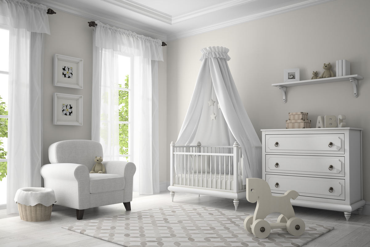 cameretta per neonati di colore bianco e grigio chiaro, con culla, poltrona bianca, ampie finestre, cavallo a dondolo, tappeto e mobile con cassetti di colore bianco