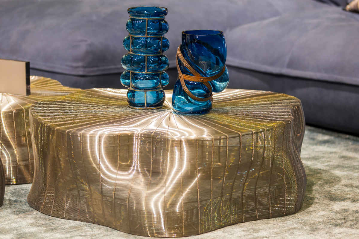tavolino dorato con vasi trasparenti e blu dal design particolare
