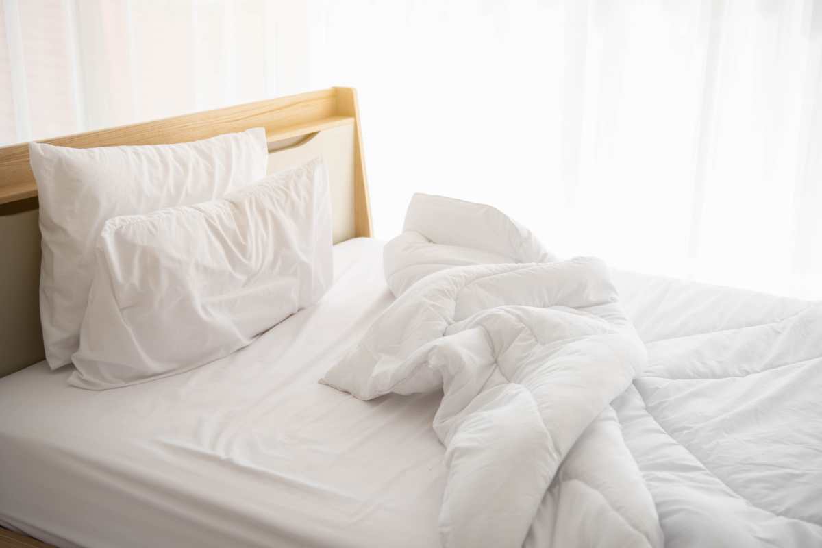 un letto disfatto vicino alla finestra