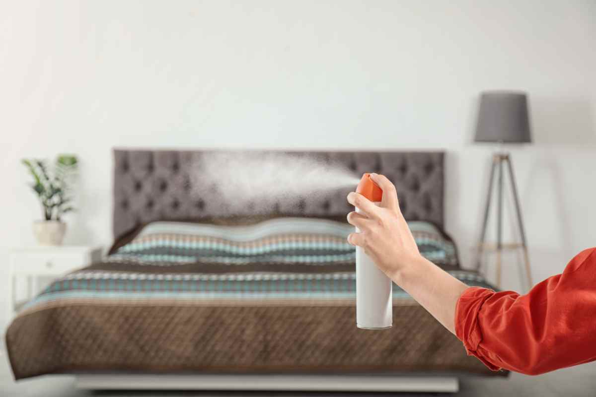 donna spruzza lo spray disinfettante nella camera da letto