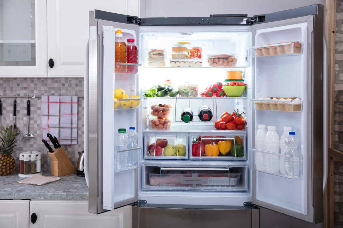 cucina con frigo no frost aperto pieno di verdure