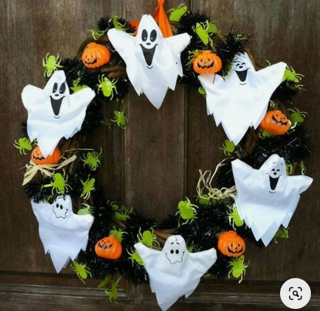 ghirlanda per halloween con fantasmi bianchi di stoffa, zucche piccole di plastica e ragnetti di carta