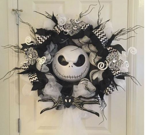 ghirlanda di halloween di colore bianco e nero appesa su una porta bianca