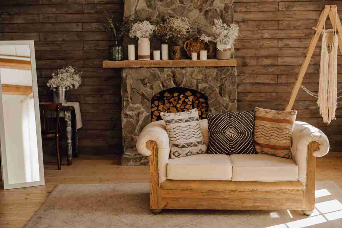 ambiente di uno chalet di montagna arredato con divano davanti al camino e specchio