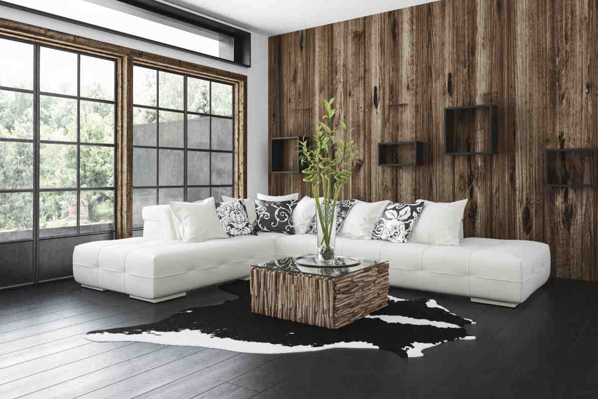 Soggiorno bianco e legno con divano angolare e scaffali alle pareti