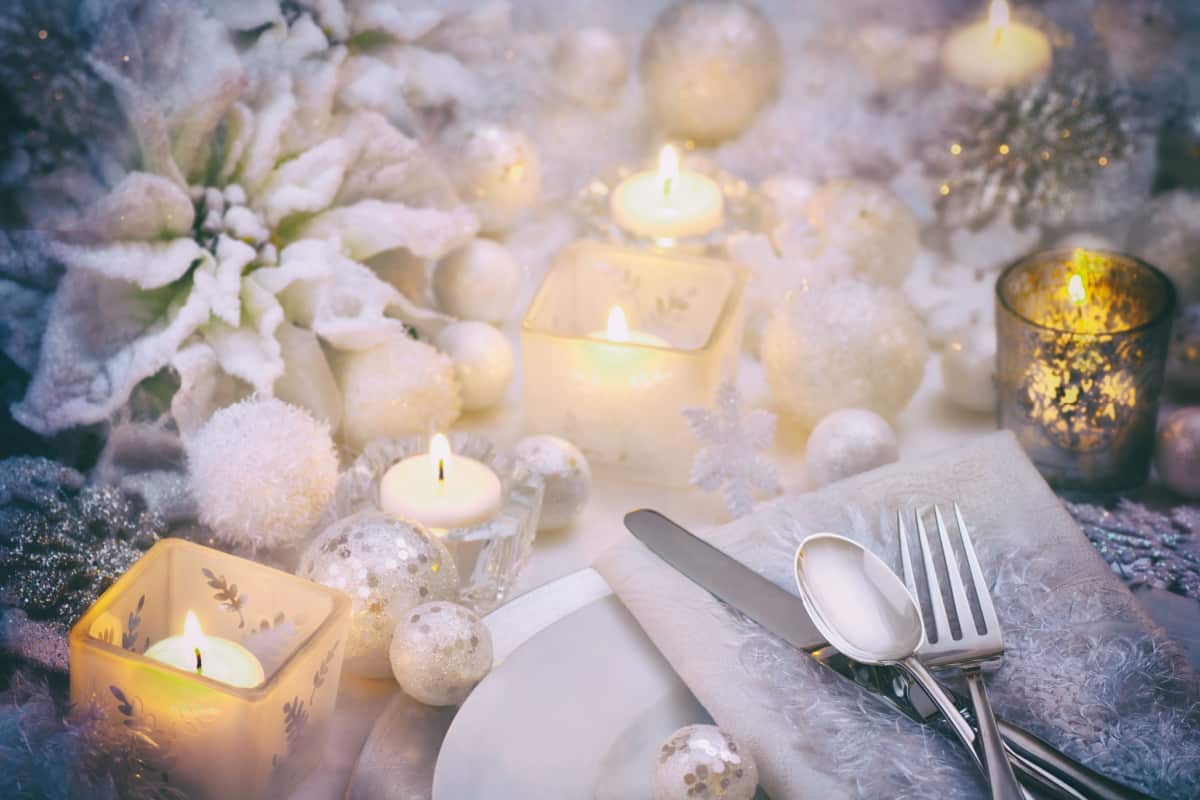 centrotavola natalizio di colore bianco con candele e fiori bianchi