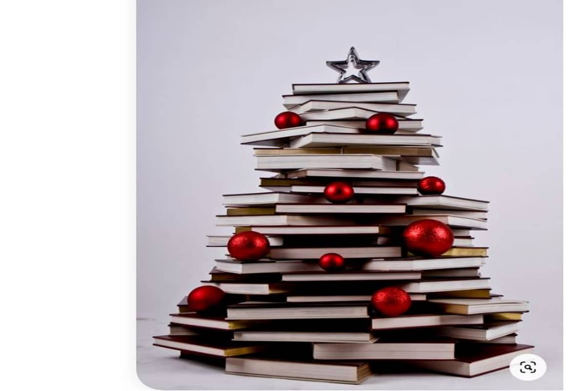 albero di natale realizzato con libri di lettura, addobbato con palline natalizie di colore rosso