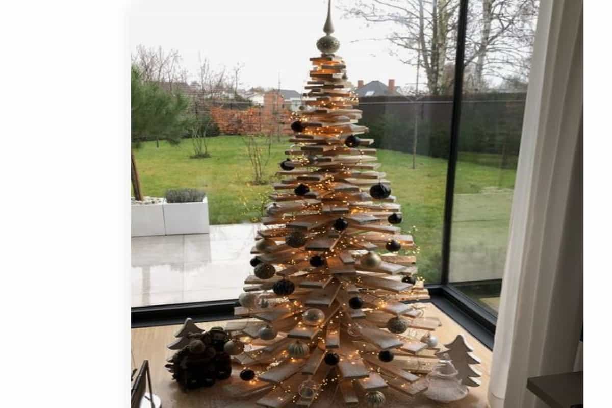 albero di natale realizzato con bancali in legno pallet, decorato con palline di natale e lucine 