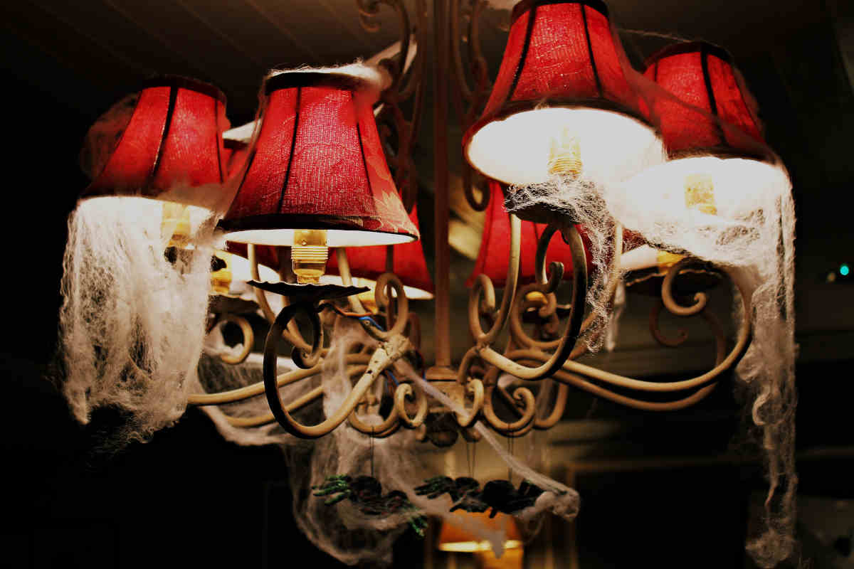 lampada da muro con paralumi rossi decorati con ragnatele di Halloween
