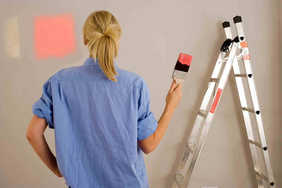 donna dipinge un riquadro a parete