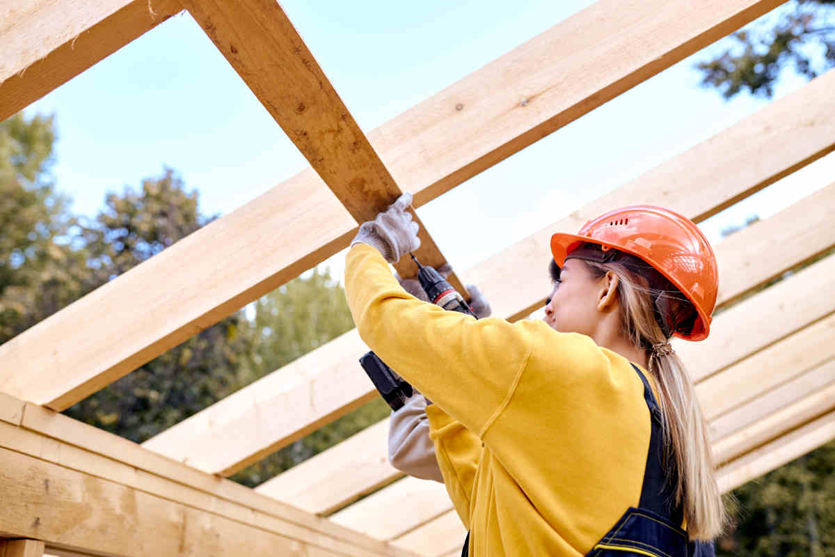 donna alle prese con lavori fai da te sulla tettoia in legno