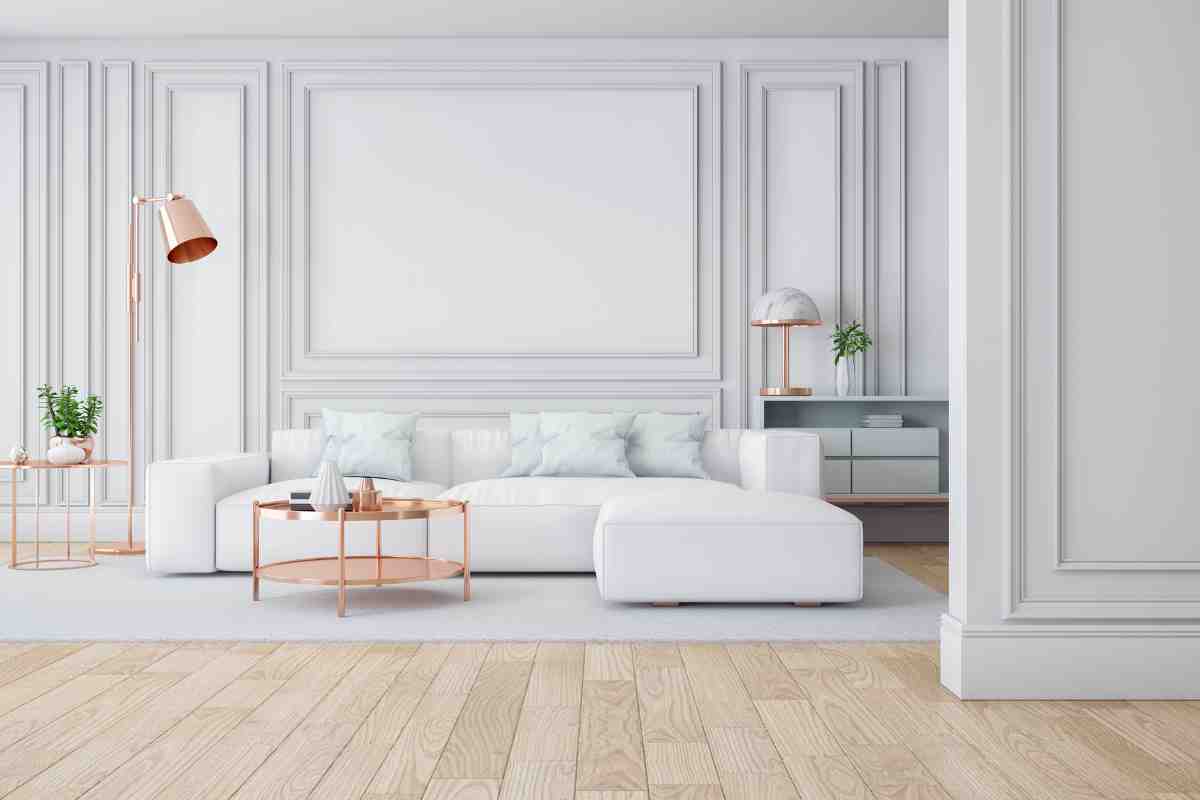 soggiorno con boiserie nei colori bianco e grigio chiaro con divano bianco