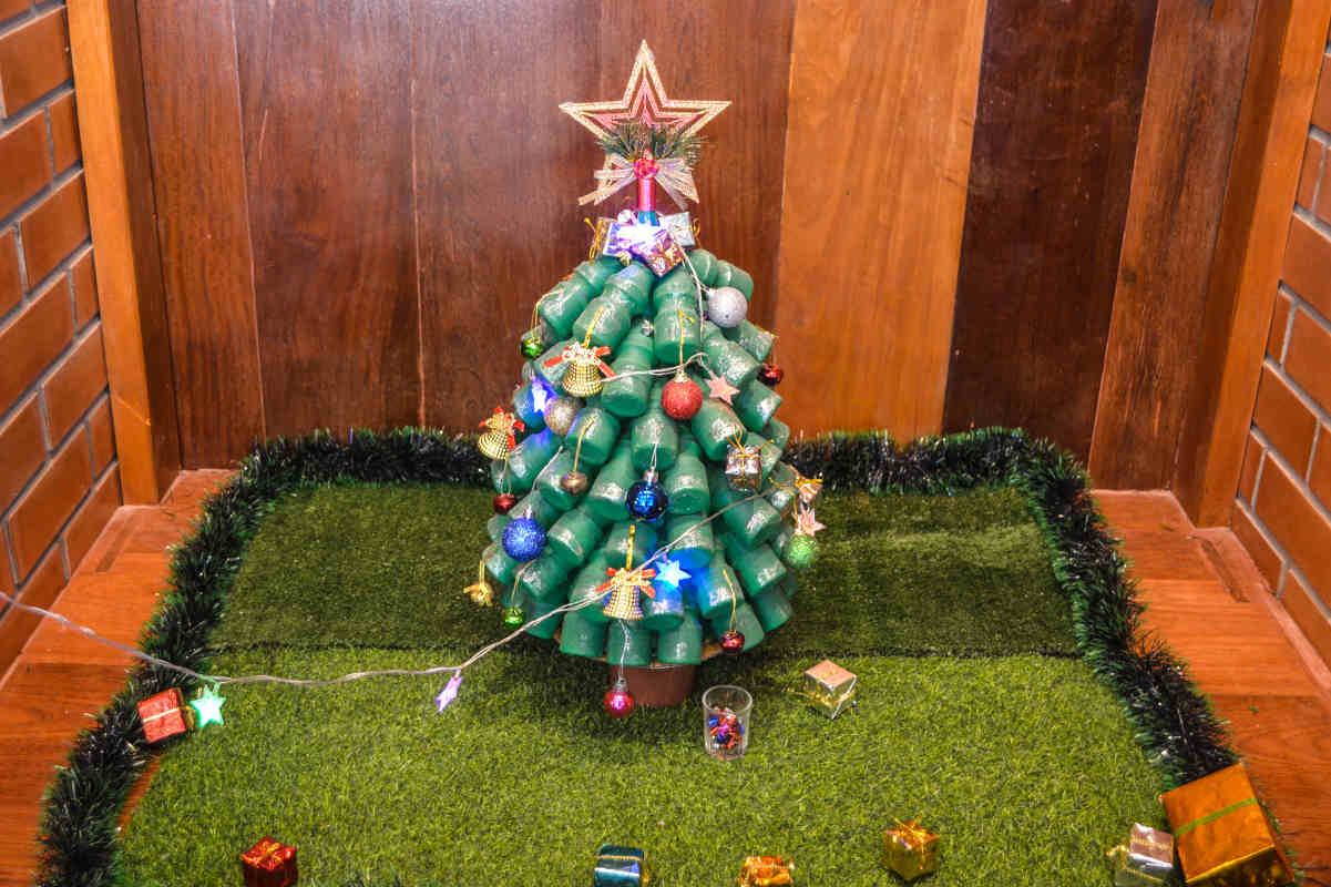 portico di casa con albero di natale con bottiglie