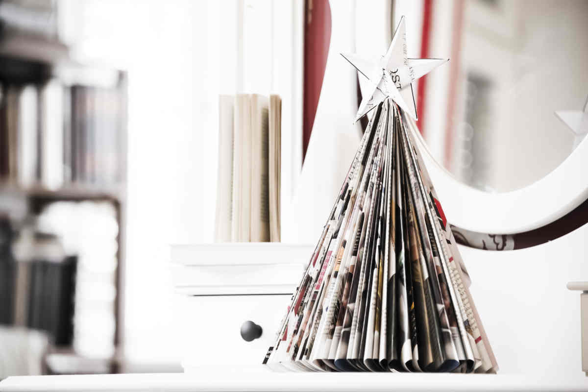 mensola su cui sta un albero di natale fatto di carta con libri