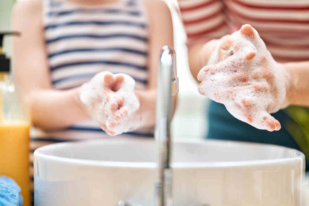 bambino e adulto si lavano le mani in bagno