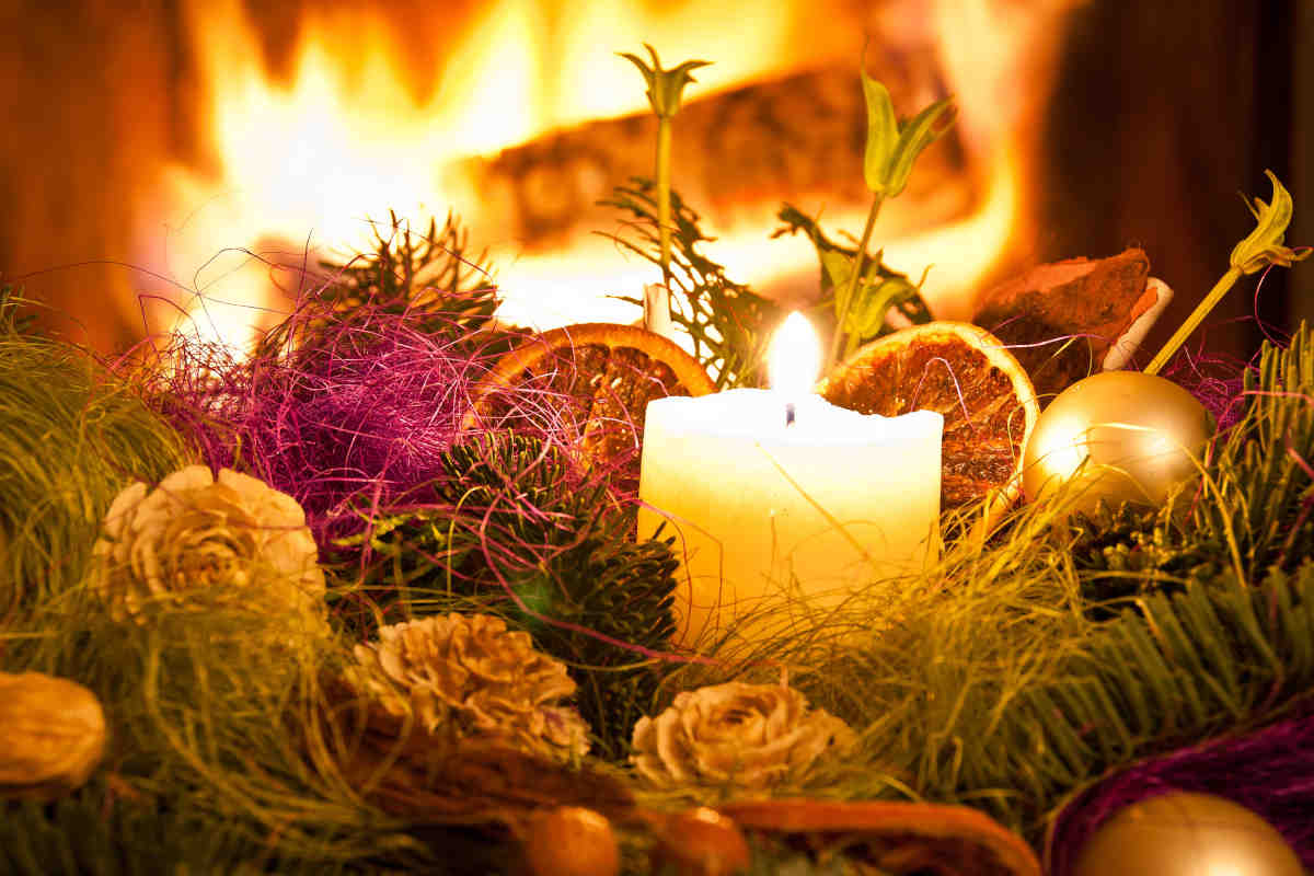Primo piano di centrotavola natalizio con pigne e candele
