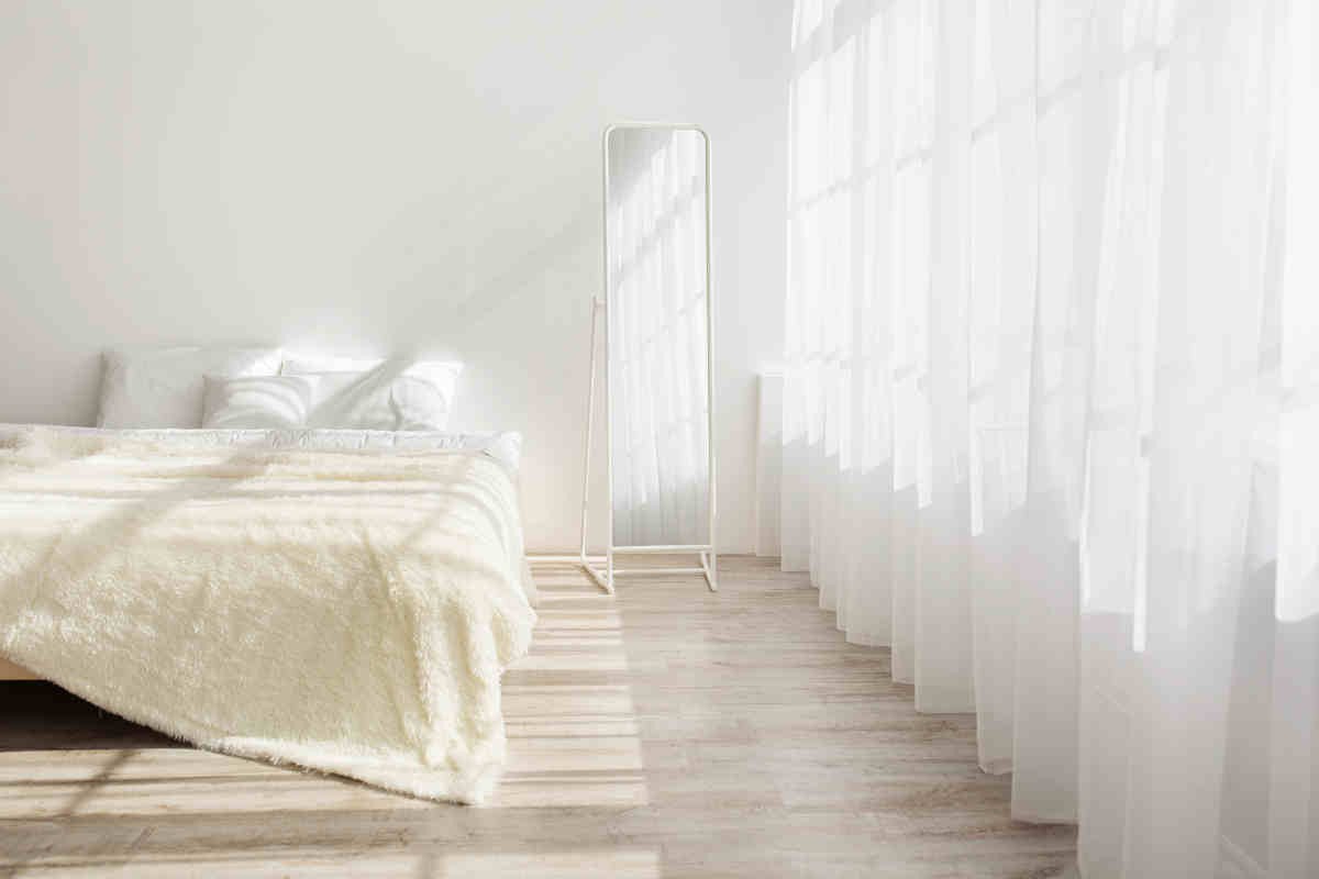 stanza da letto bianca con tende bianche