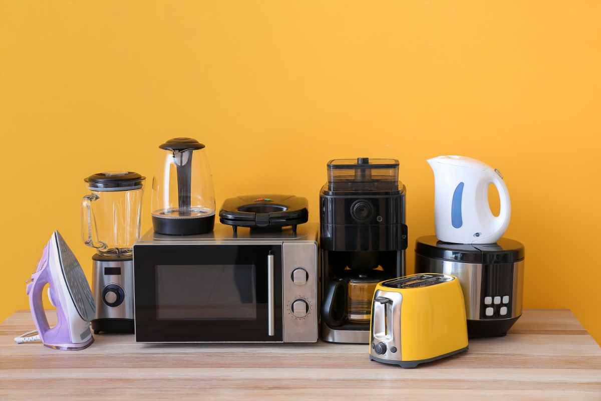 piccoli elettrodomestici colorati su tavolo di legno a cui staccare la spina
