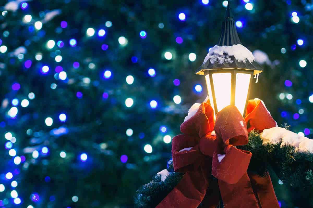lampione da giardino decorato con un fiocco rosso natalizio