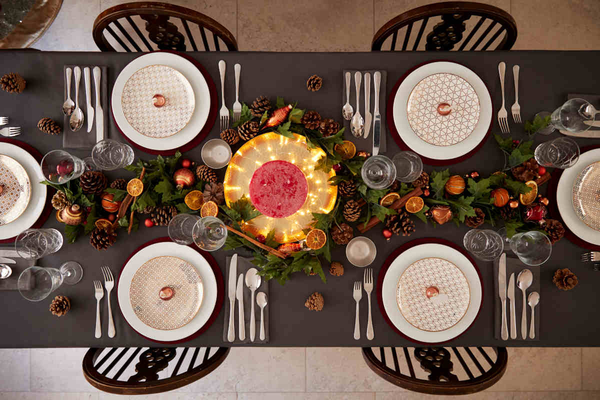 tavola apparecchiata con piattini natalizi e decorazioni