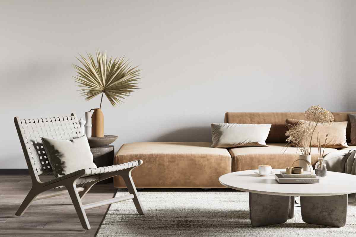 soggiorno stile wabi sabi con sedia davanti a un divano in tessuto beige e tavolino