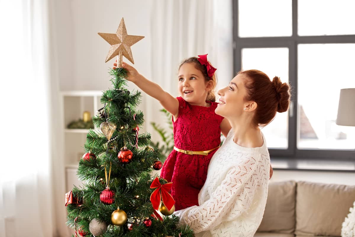 mamma e figlia posizionano puntale dellalbero di Natale