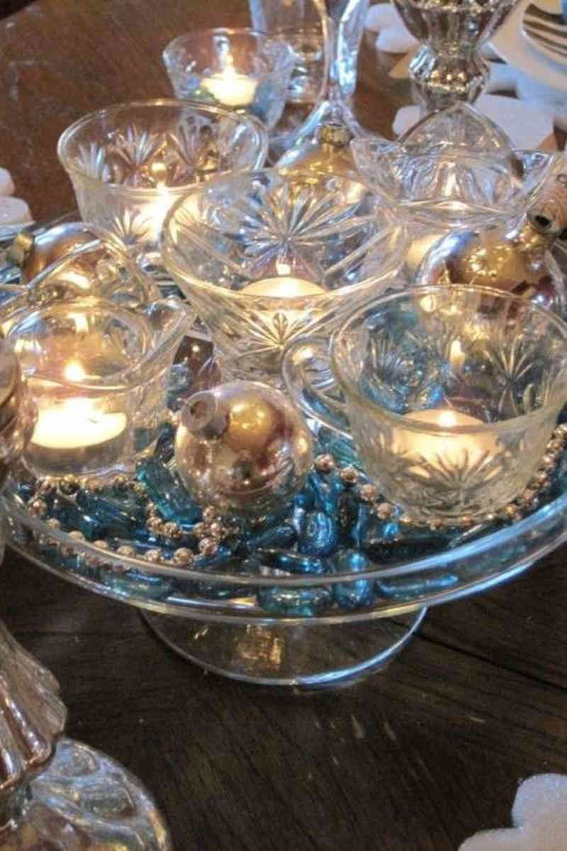 Alzatina di vetro con confetti colorati, palline di natale e candele per il centrotavola di capodanno economico