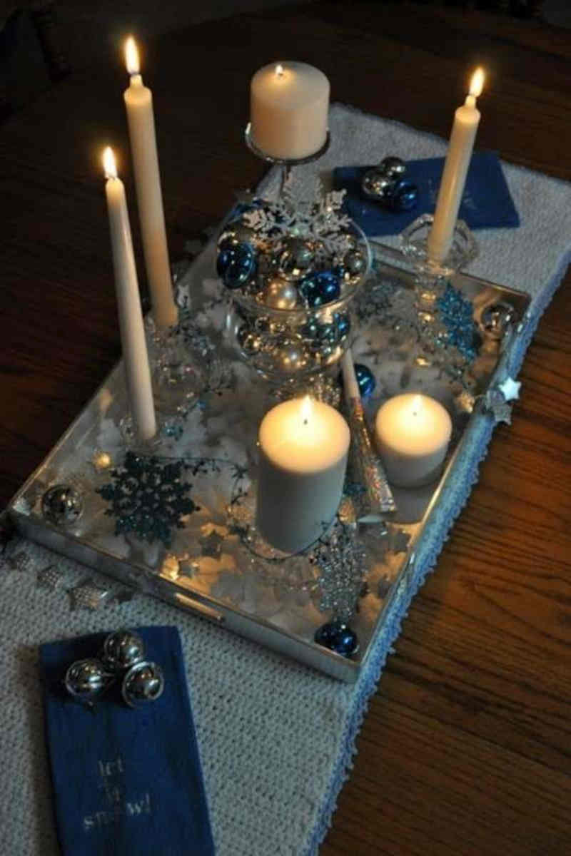 decorazioni per la tavola di capodanno con candele di diversa forma e dimensione, raccolte in un centrotavola