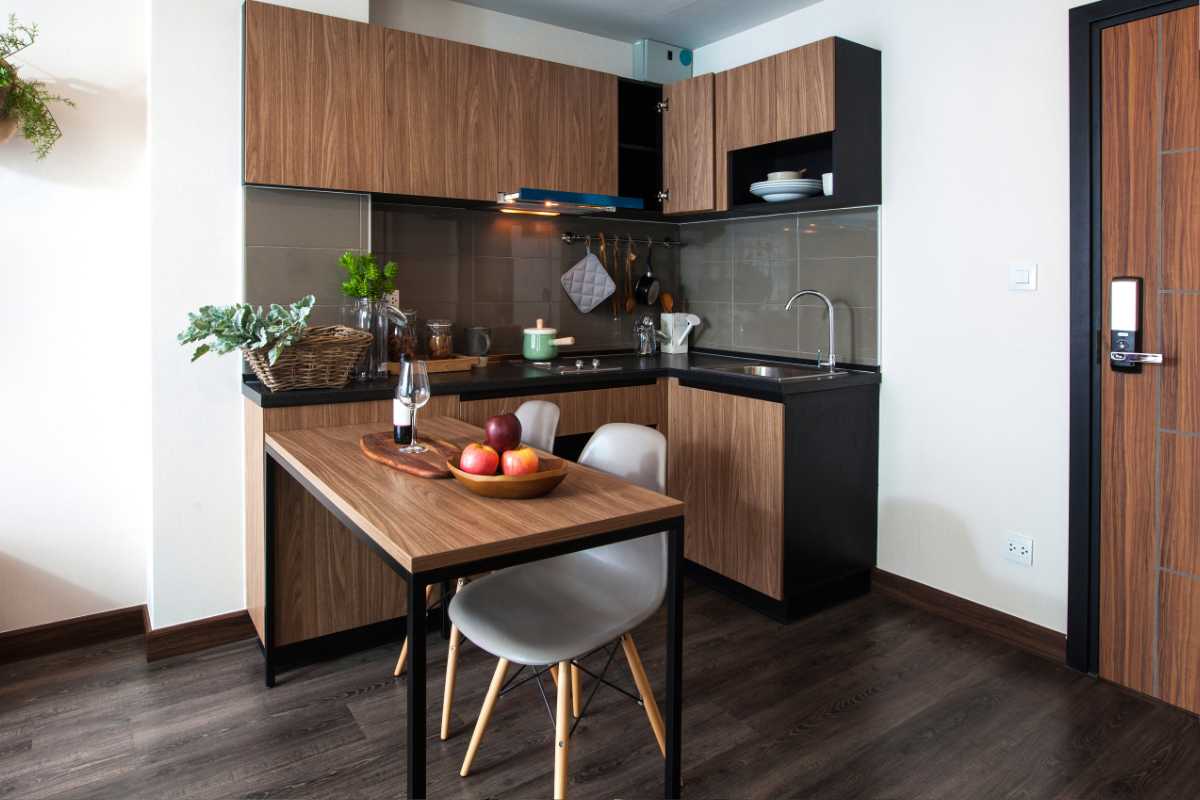 una cucina ad angolo con tavolo a penisola in legno