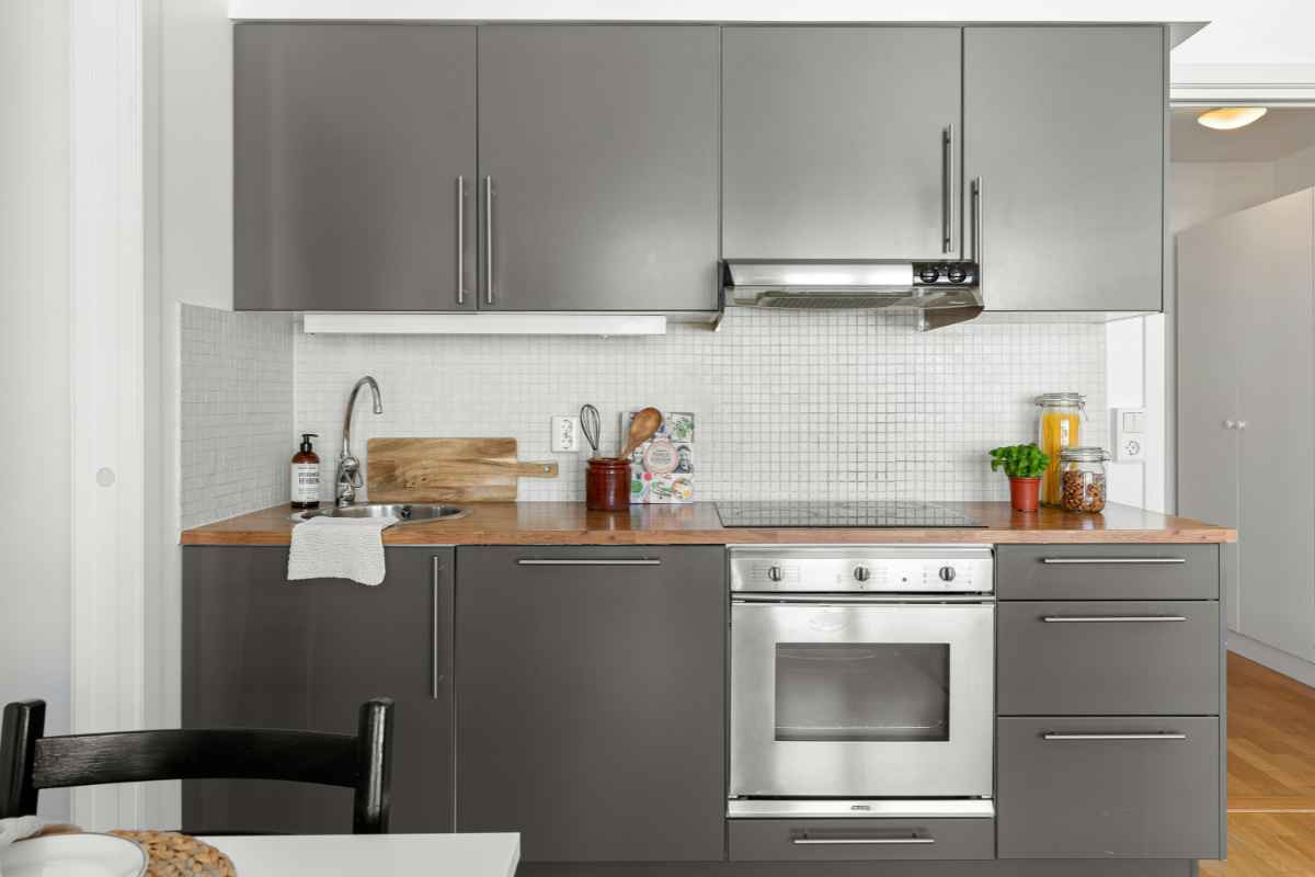 una cucina monoblocco moderna con ante di colore grigio