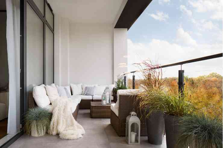 balcone con divanetto e tavolino, lanterne e piante