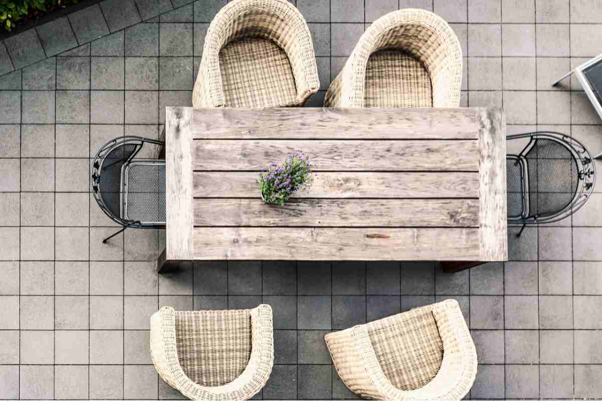 Terrazzo stile industriale con tavolo in legno e poltroncine in metallo visti dall'alto