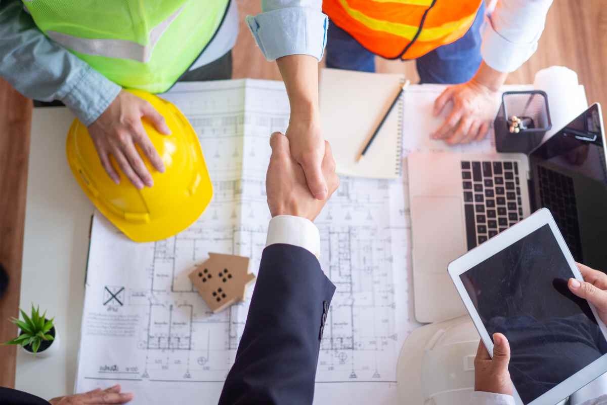geometra e ingegnere si stringono la mano su un progetto per sanare abusi edilizi
