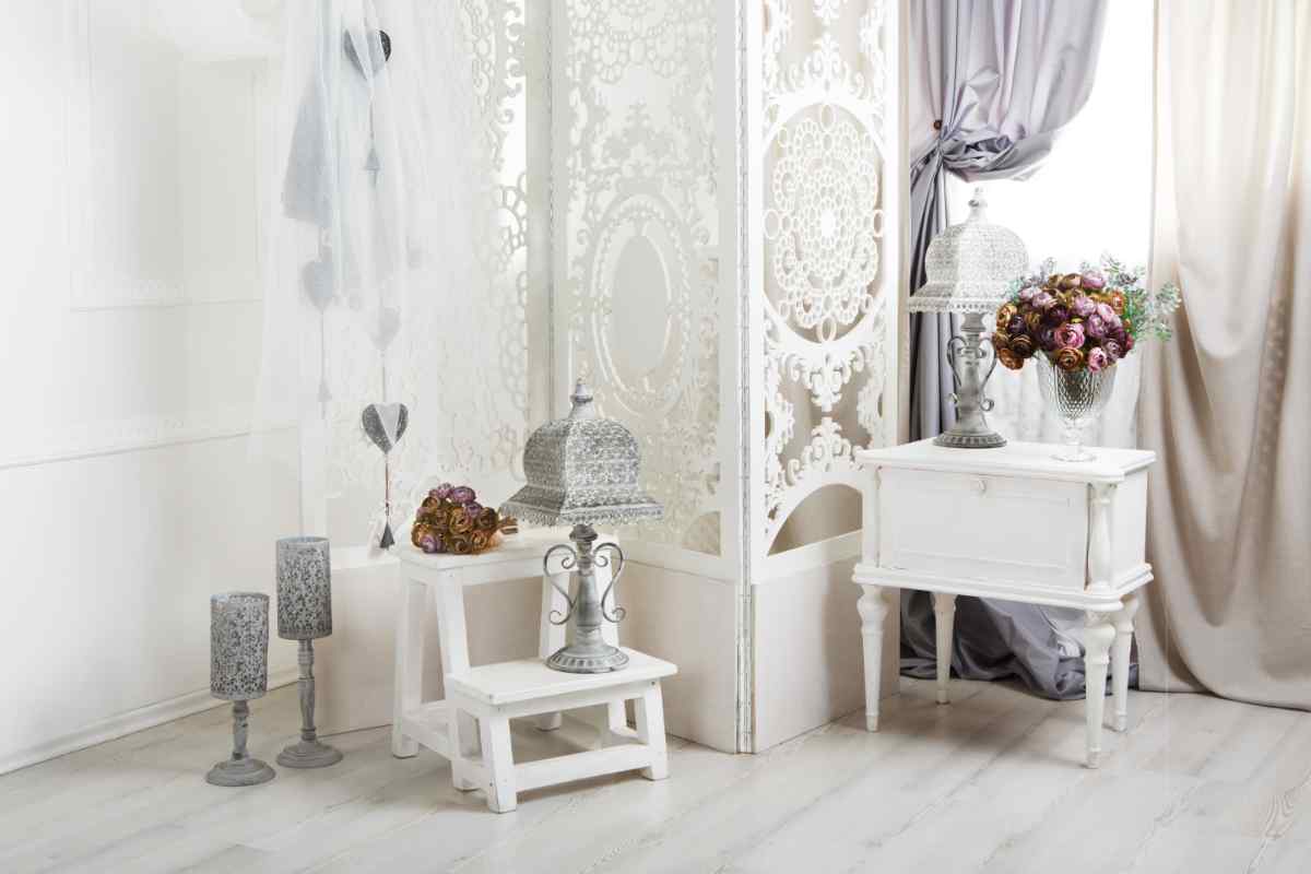 arredamento shabby chic con mobili decapati, piccola credenza, scaletta e paravento intarsiato