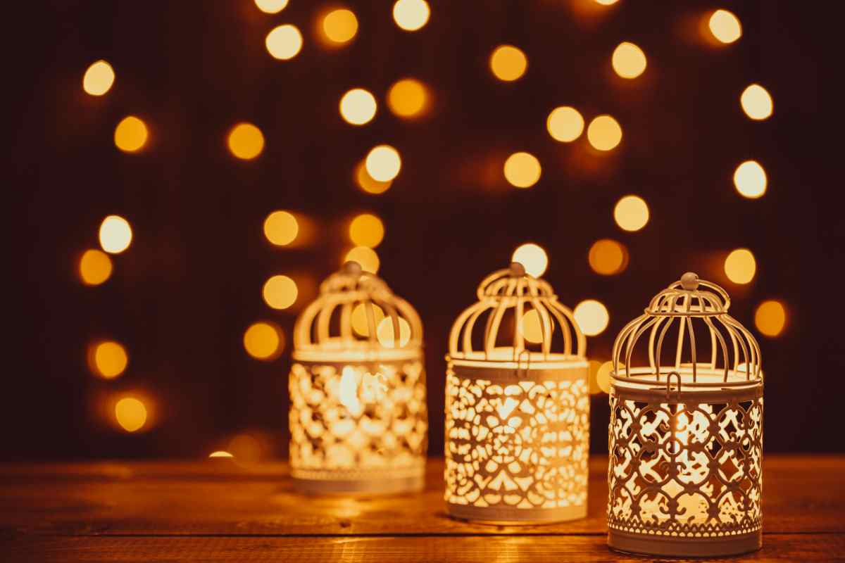 tre lanterne fai da te illuminate con luci sfocate sullo sfondo