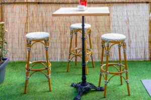 Terrazzo con erba sintetica con sgabelli e tavolo
