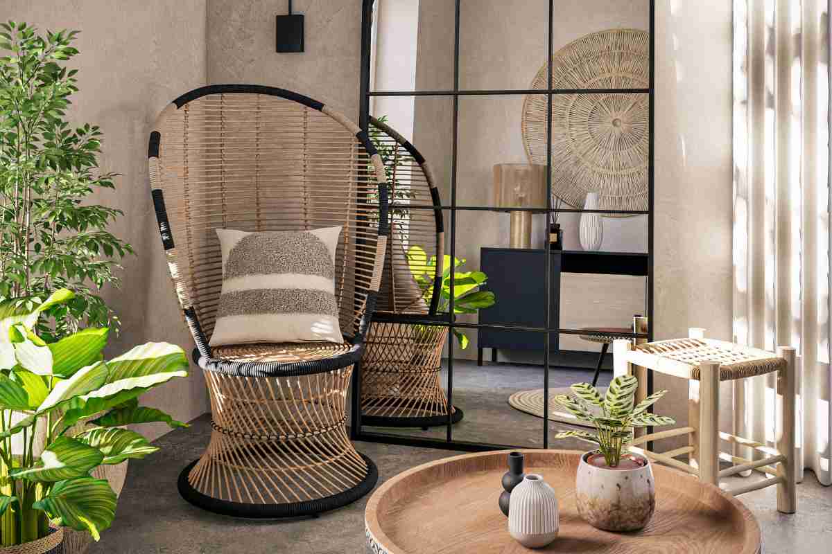 soggiorno con arredamenti in rattan di tendenza, sedia boho, sgabello, decorazione sulla parete