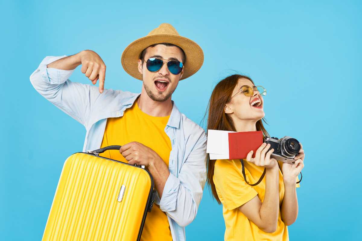 giovane coppia di turisti con valigia e passaporto