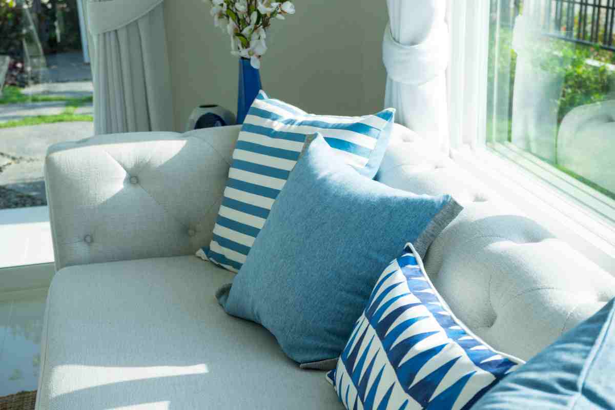 divano beige e cuscini a fantasia azzurri stile coastal
