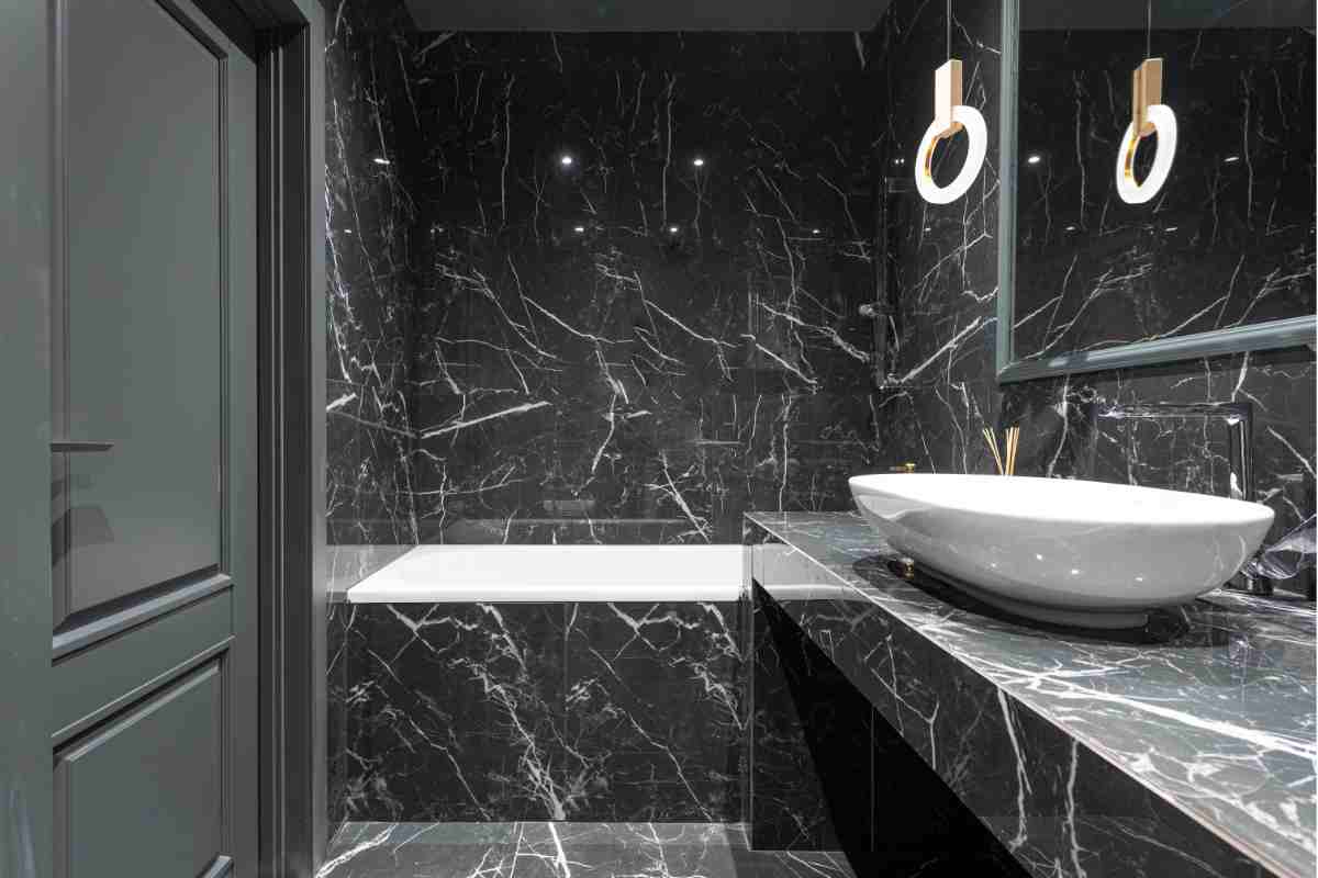 bagno con rivestimenti in marmo nero