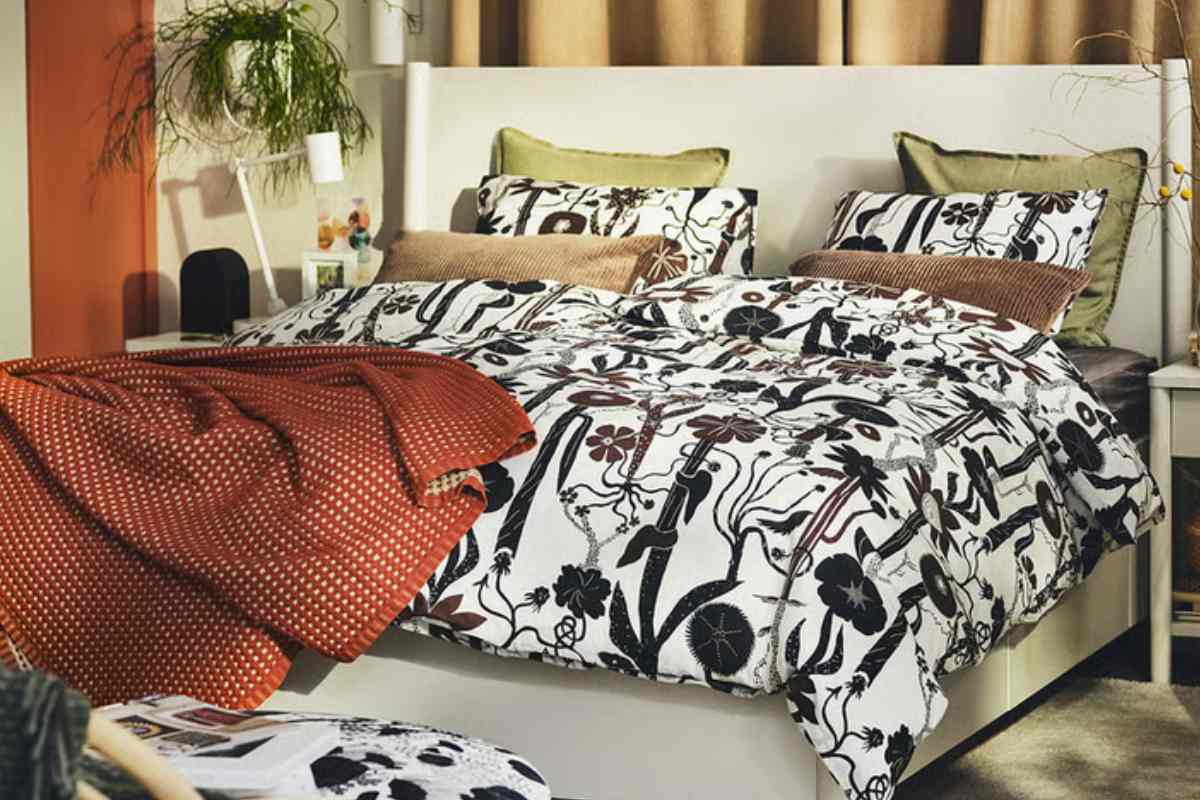 una camera da letto con un letto vestito con il copripiumino Ikea LUNDSKAFTING