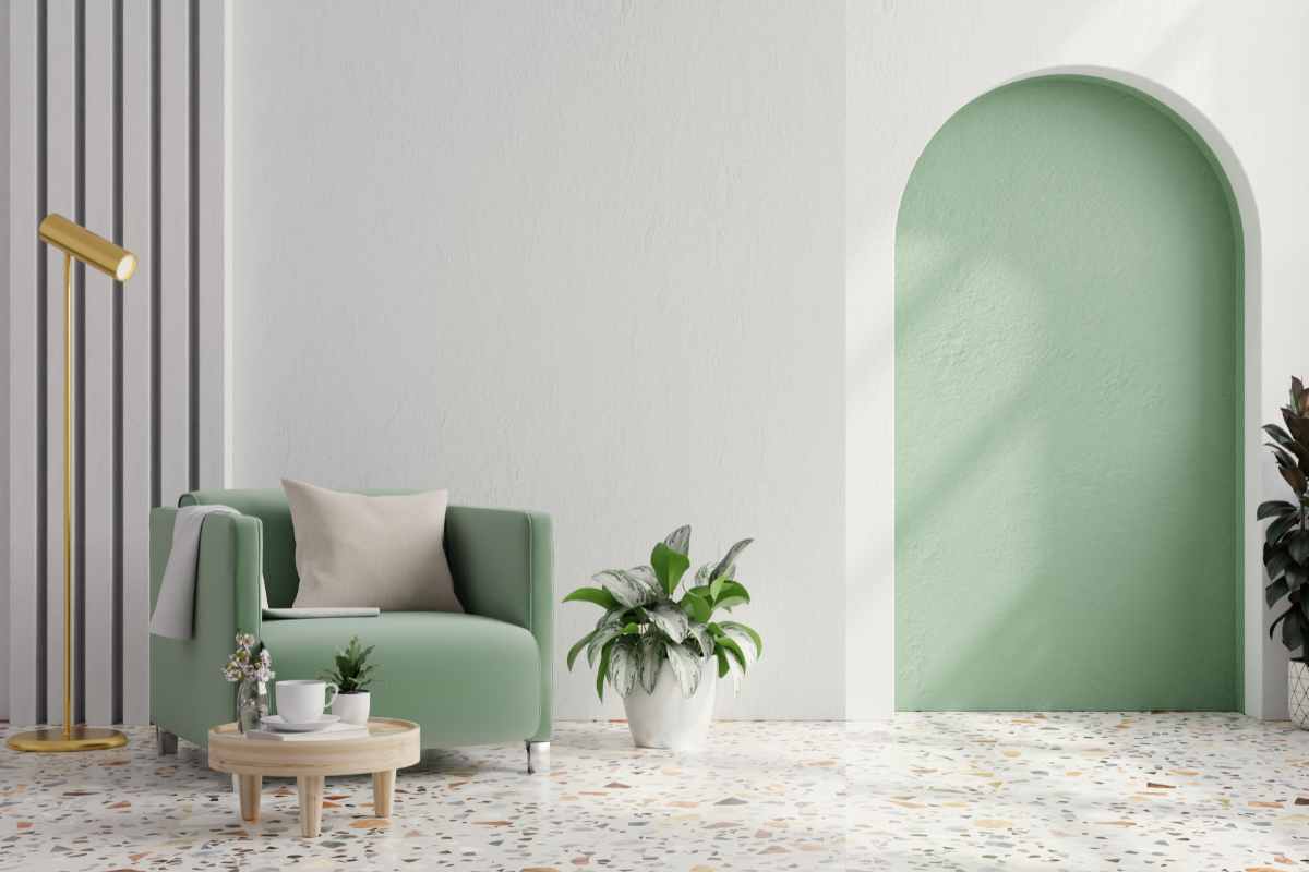 ambiente soggiorno con poltrona in verde salvia e parete della nicchia dipinta nella stessa tonalità