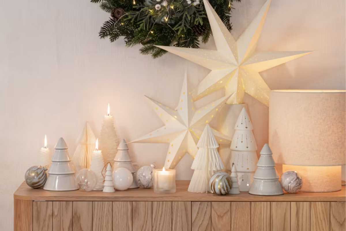 una madia con sopra tante decorazioni natalizie bianche Maisons du Monde