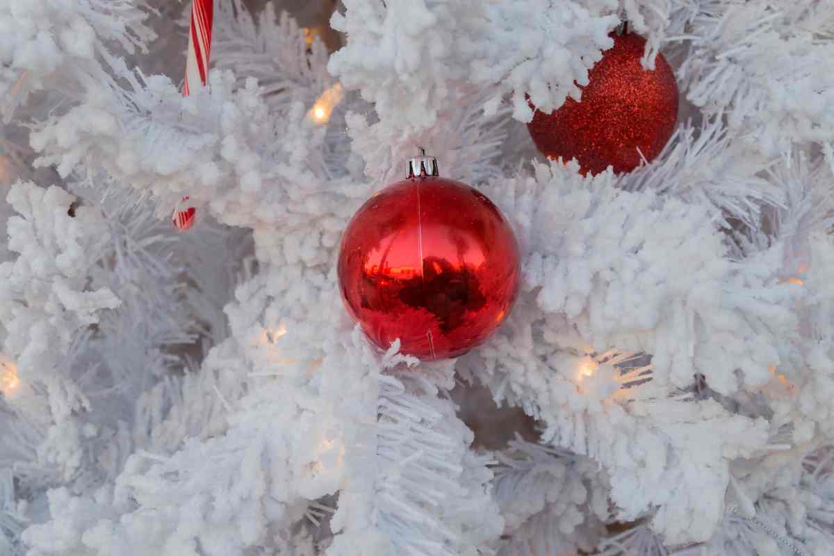 un albero di natale bianco con luci led e palline rosse