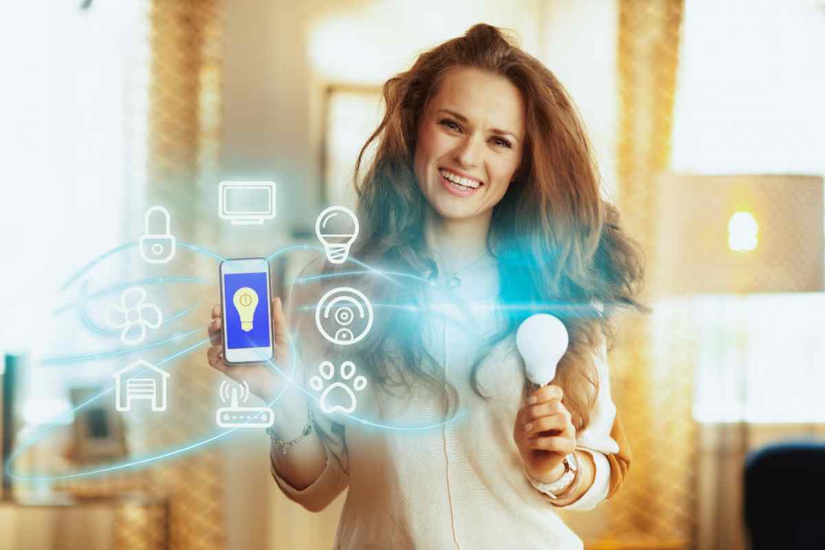 ragazza con lampadina e smartphone in mano simbolo di come scegliere lampade intelligenti