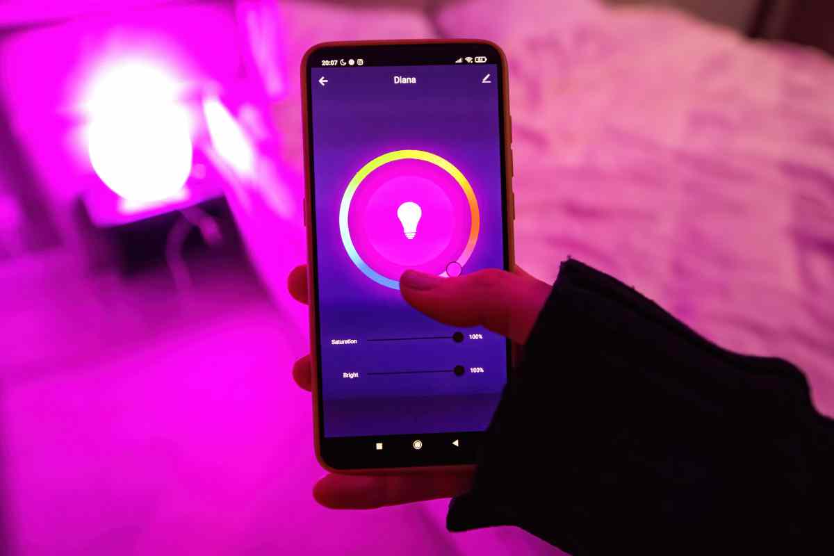 mano su smartphone gestisce lampadine intelligenti