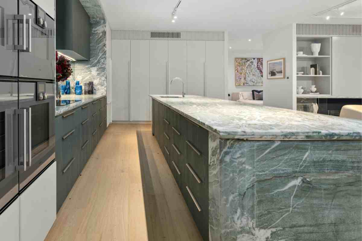 cucina in marmo verde e pietra con isola e pavimento in legno