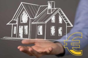 Sagoma di una casa in gesso e mano che la tiene sollevata
